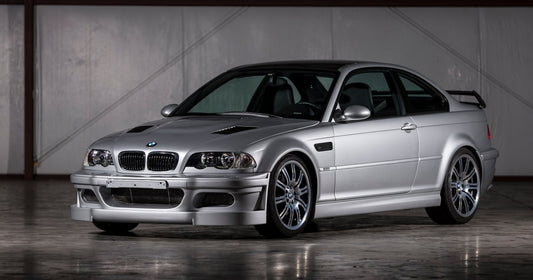 BMW E46 M3 CSL, showcasing its lightweight design, aggressive styling, and distinctive rear wing. The image highlights the car's sporty appearance and performance-oriented features.