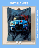 Person holding a soft blanket with a blue car design BMW M4 G82, branded 'Bavarian Oldschool'.