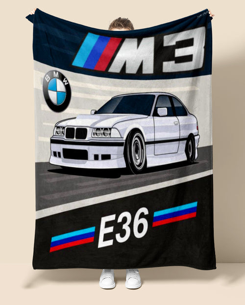 Person holding a BMW M3 E36 blanket with car and brand logos.