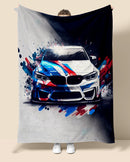 Person holding a blanket with a BMW M4 car design featuring splashes of red, blue, and white.