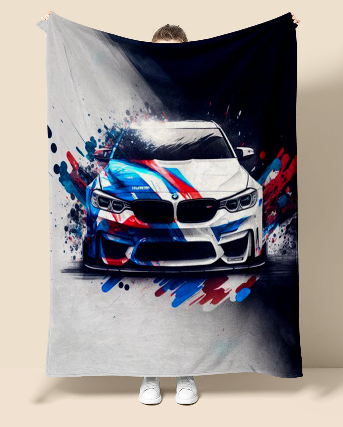 Person holding a blanket with a BMW M4 car design featuring splashes of red, blue, and white.