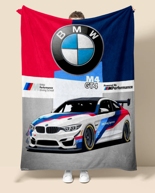 Person holding a BMW M4 GT4 car-themed blanket with the BMW logo.