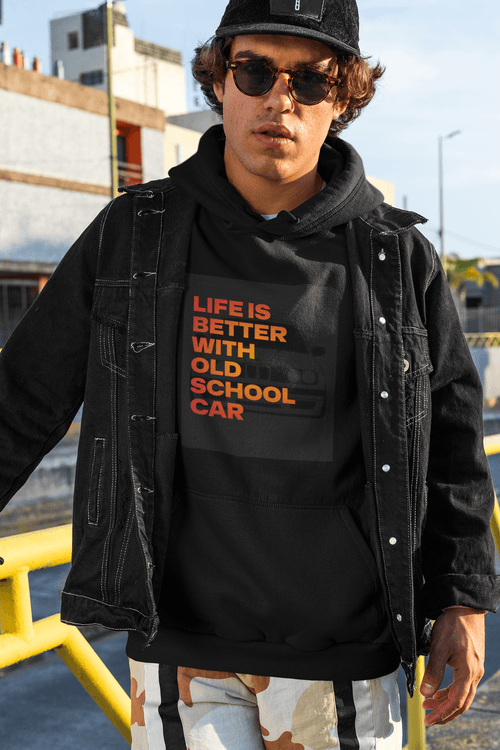 Person wearing a black hoodie with text Life is better with old school car and graphics BMW e30 and a black jacket outdoors. Bavarian old school