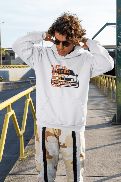 Person wearing a white hoodie with text and graphics, standing outdoors on a sunny day. Life is better with old school car. Bavarian old school