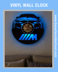 Vinyl wall clock shaped like a car with BMW logo on a wall. Bavarian old school