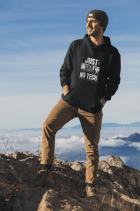 Person wearing a black hoodie with text  Just skill no tech, standing on a mountain with a blue sky and clouds in the background. Bavarian old school