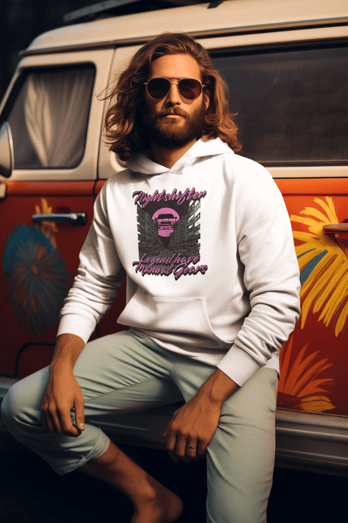Man wearing a white hoodie with graphic design sitting in front of a colorful van.
