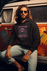 Man wearing a black hoodie with text sitting in front of a colorful van.