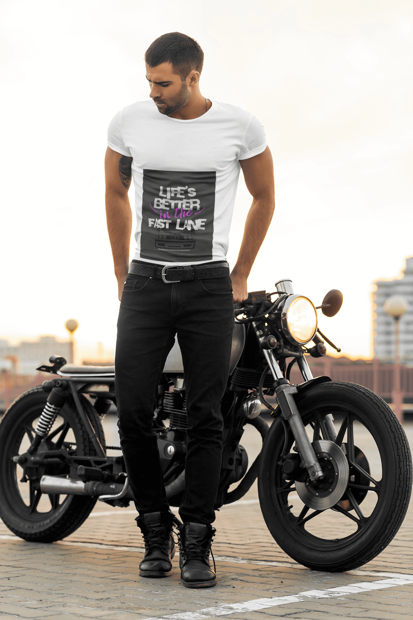 Man standing next to a motorcycle wearing a white t-shirt with text Life`s better in the fast lane. Bavarian old school